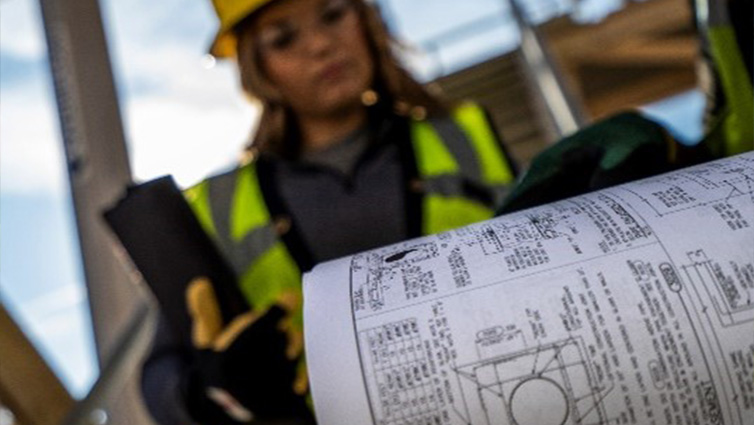 female and male construction workers in hardhats and protective glasses